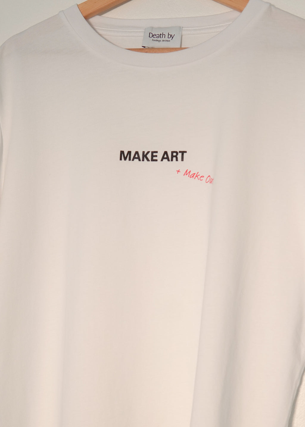 White t-shirt with 'MAKE ART' text on a white background